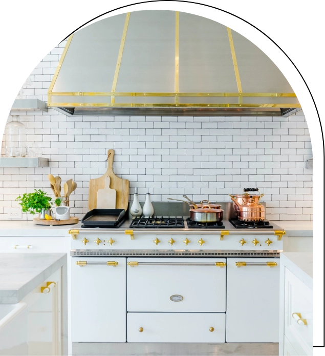 A white stove with gold trim in the kitchen.